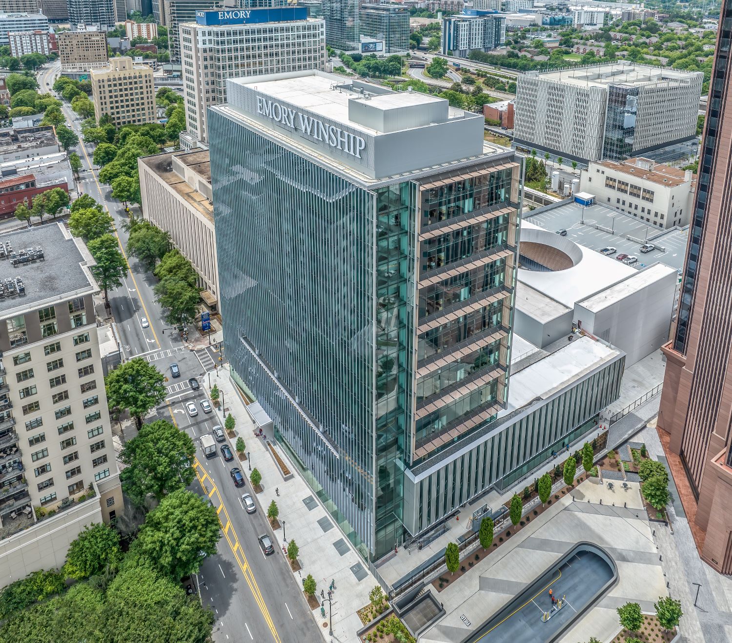 aerial view of tall hospital building with other city buildings around it