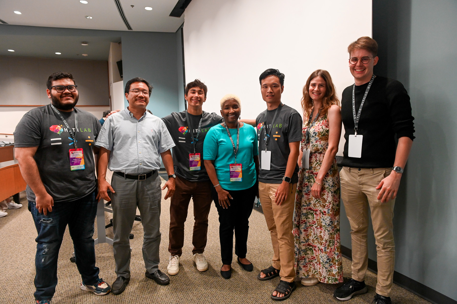 seven smiling people standing in a row