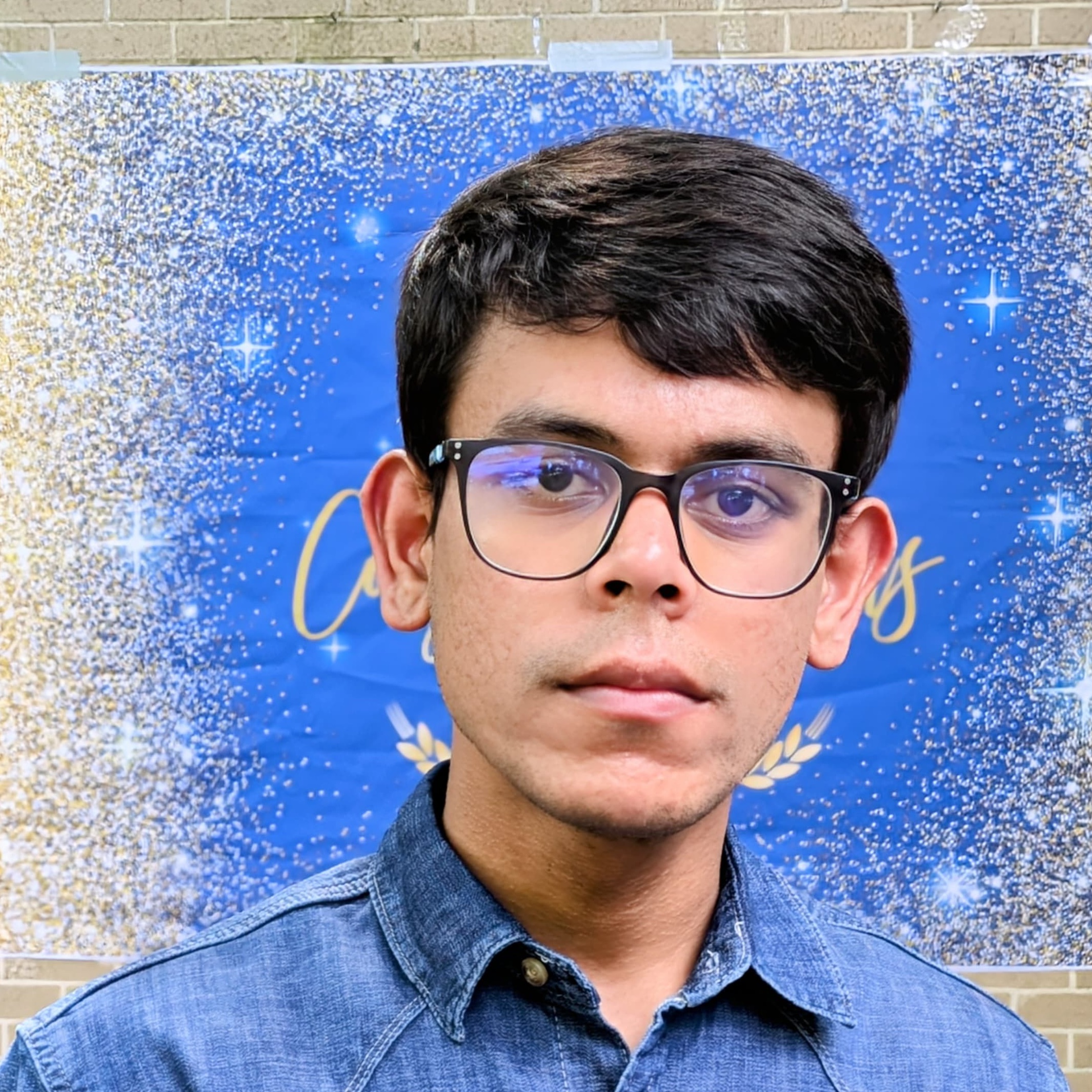 headshot of man with blue background