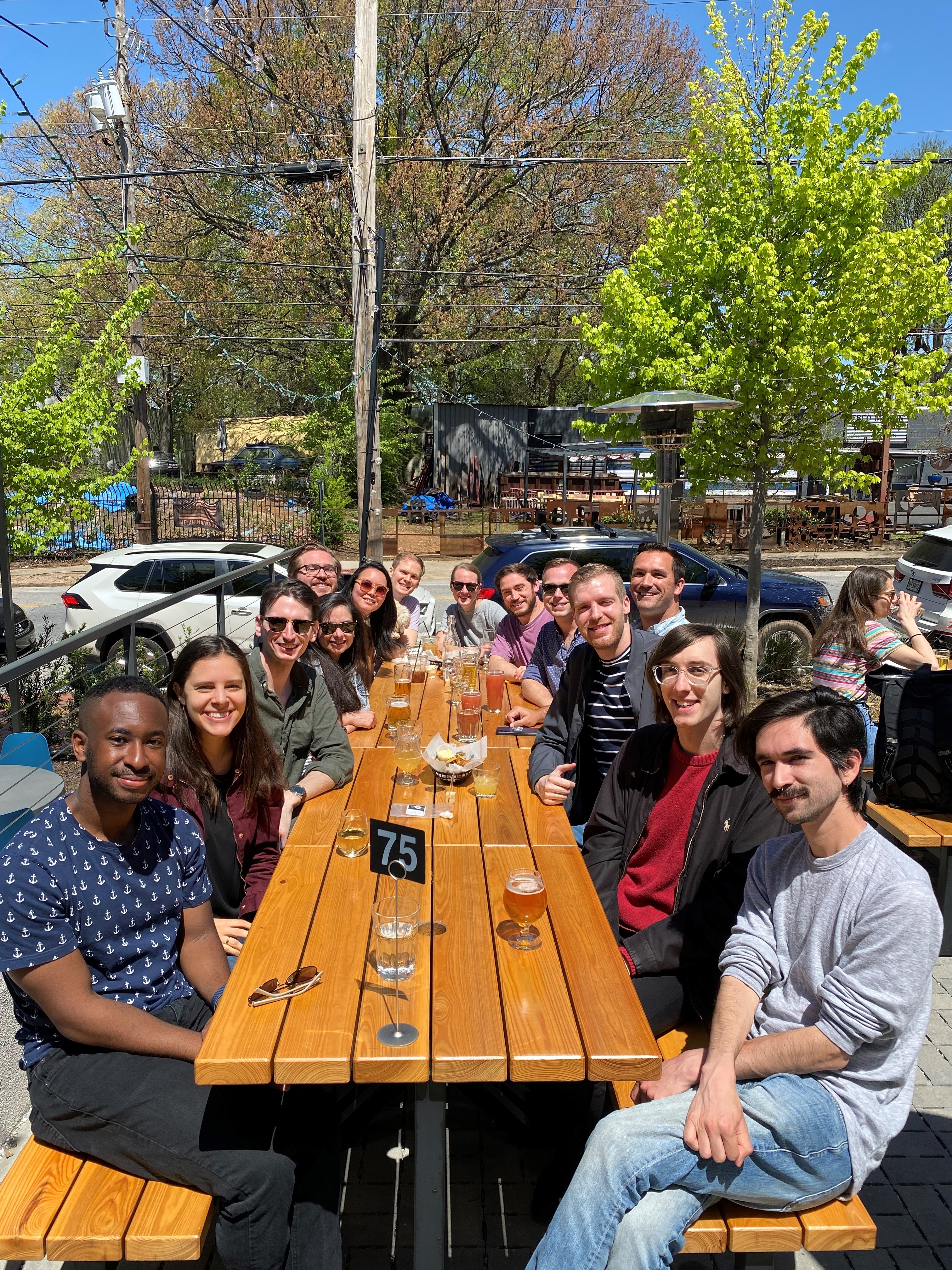 Group of residents sit at a table on an outdoor patio