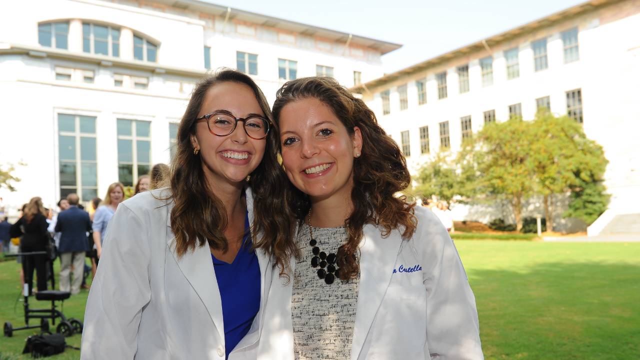 Two women standing on the lawn in front of the SOM building