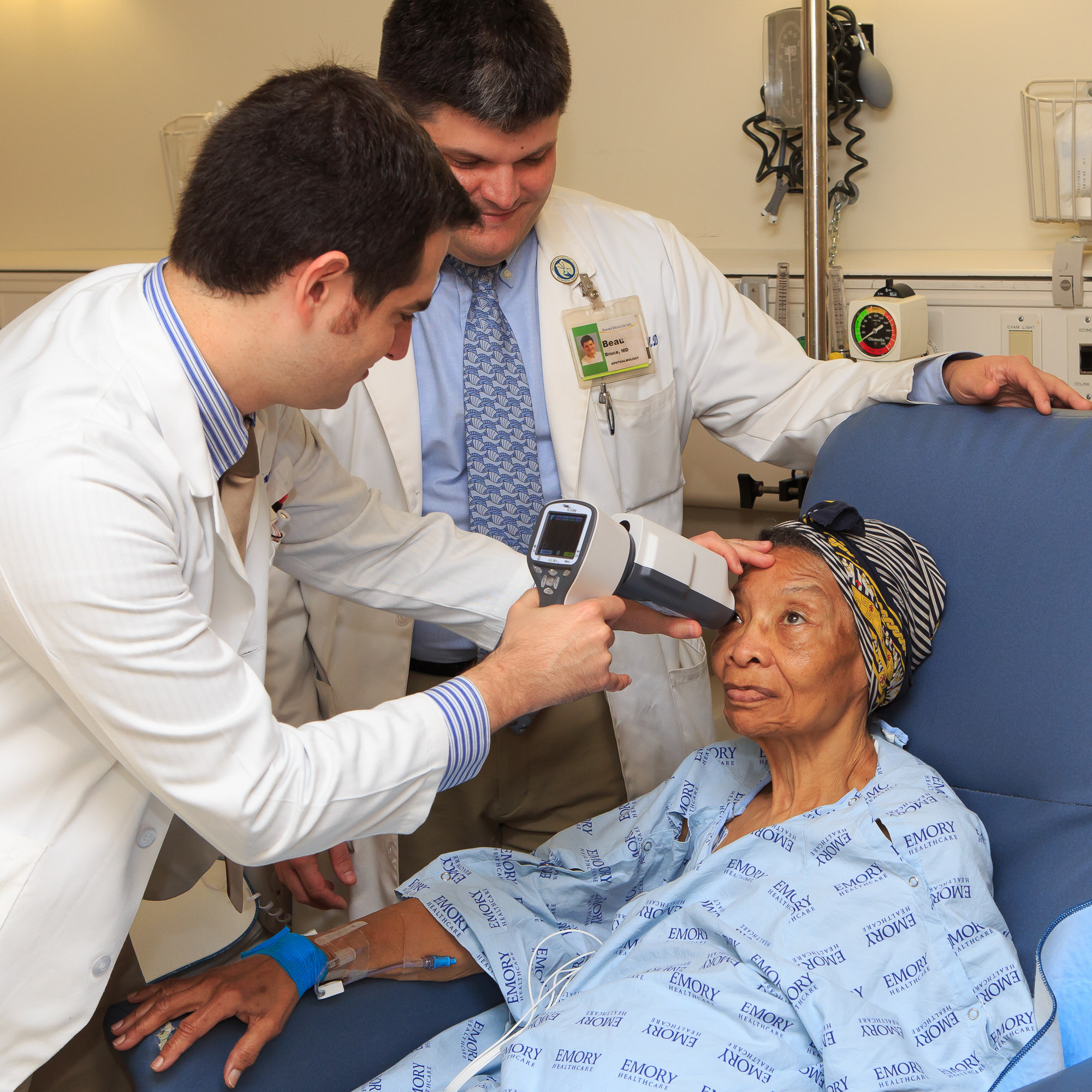 Student performing eye examine with faculty member observing