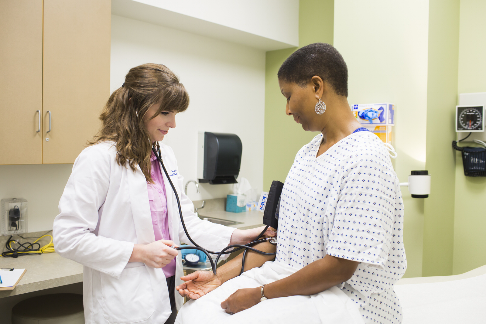 student taking blood pressure at bedside