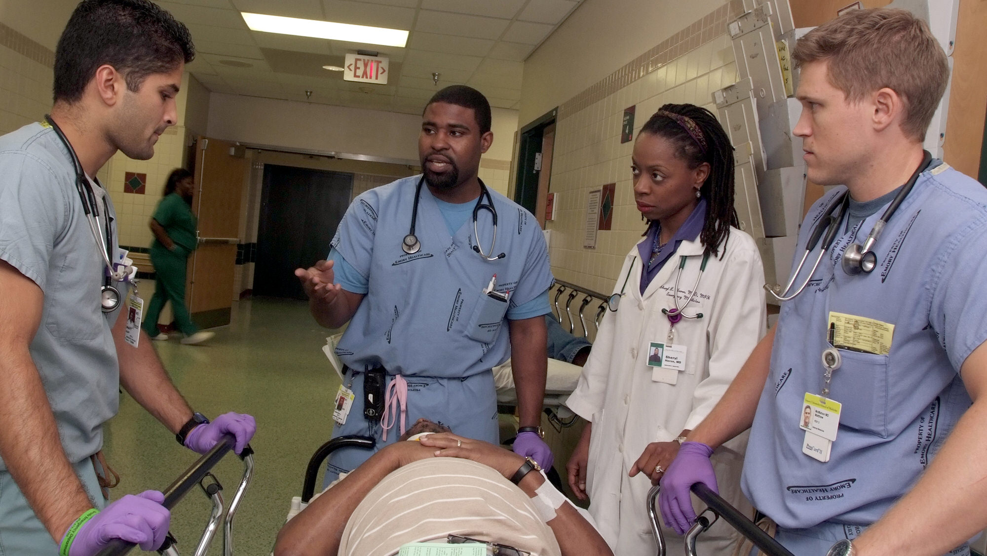 Faculty and students surrounding patient in bed