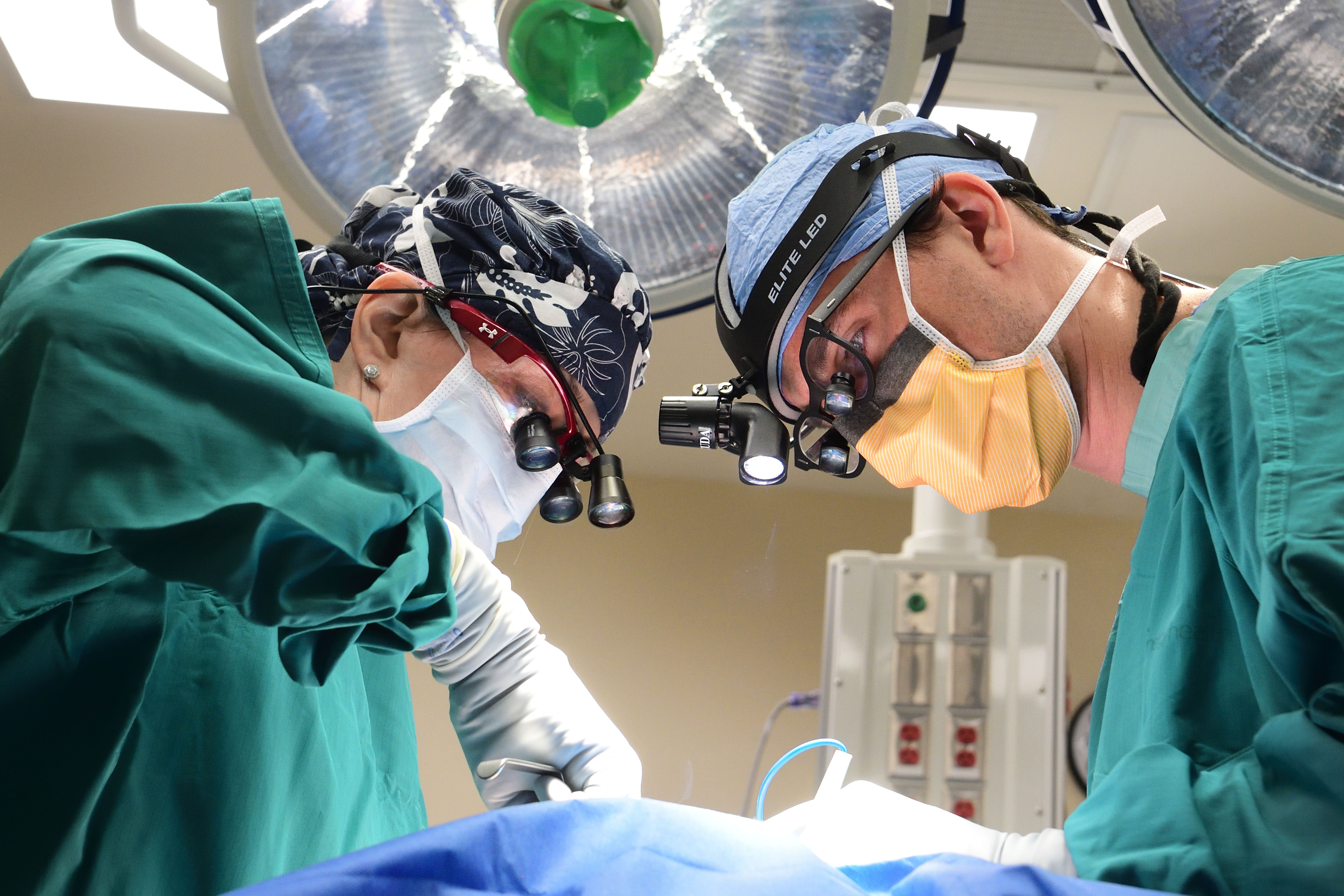 Student examining patient's eyes with instructor observing