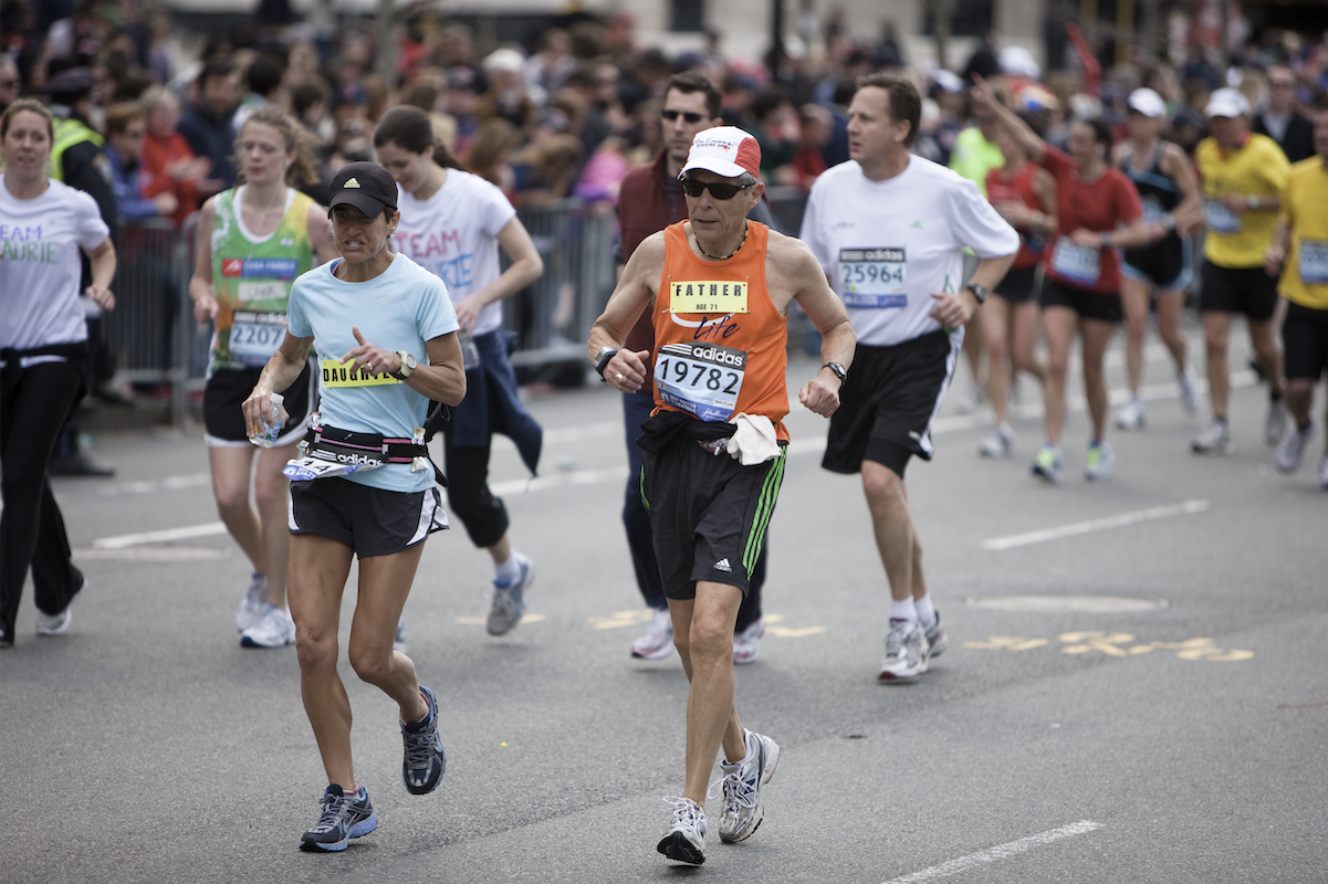 A group of street runners wearing shorts, tank tops and numbered bibs