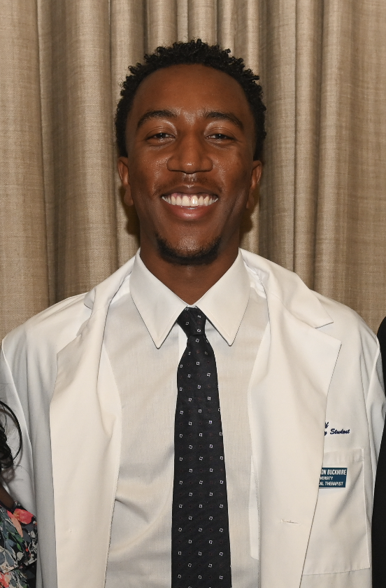 Michael Buckmire poses for a picture while wearing a white lab coat