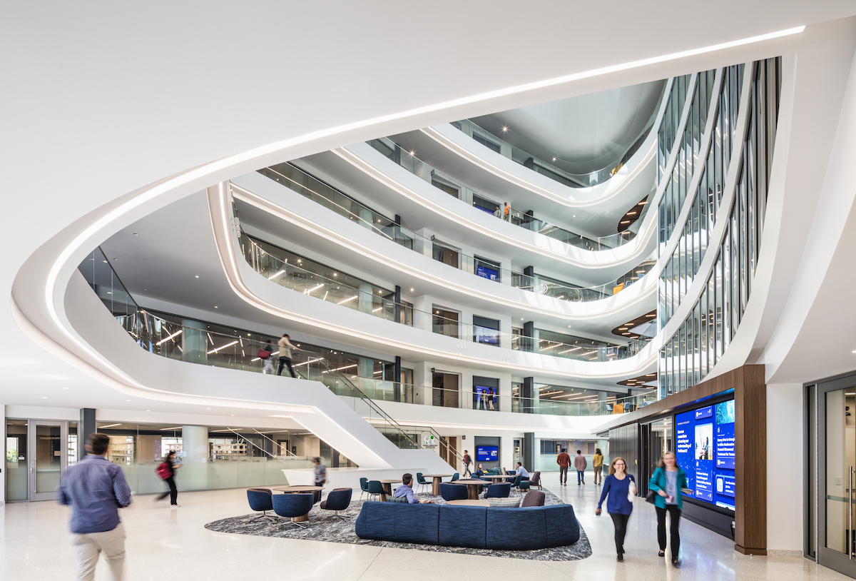 People gather and enjoy research in the atrium of the HSRB. The digital experience zones Nexus and Info Cores can be seen in the image.  